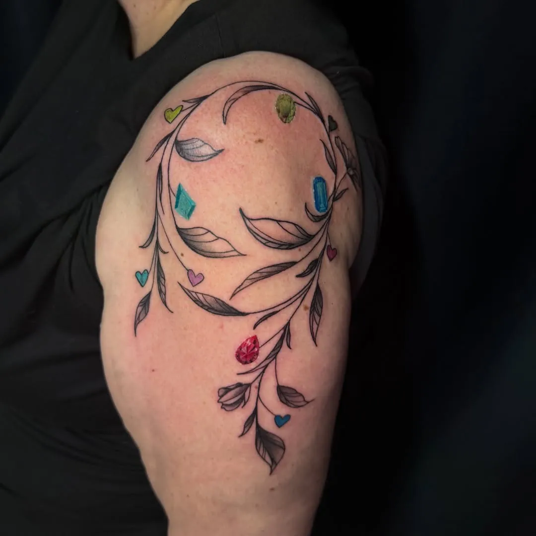 Fine line botanical vine tattoo with colour gemstones