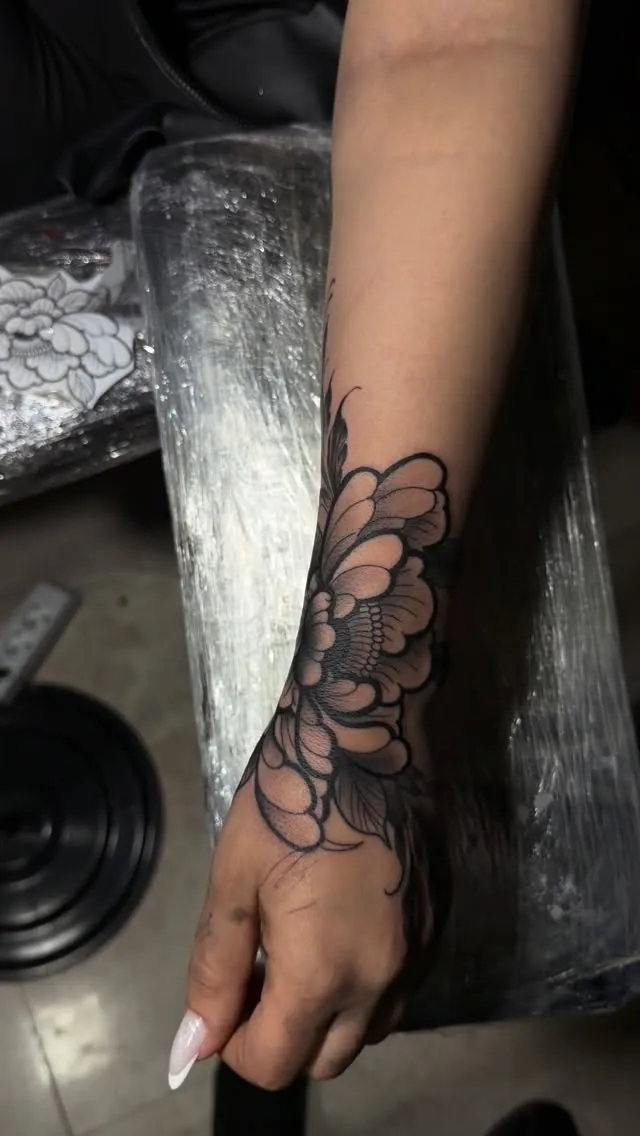 Fine line floral mandala tattoo on the hand