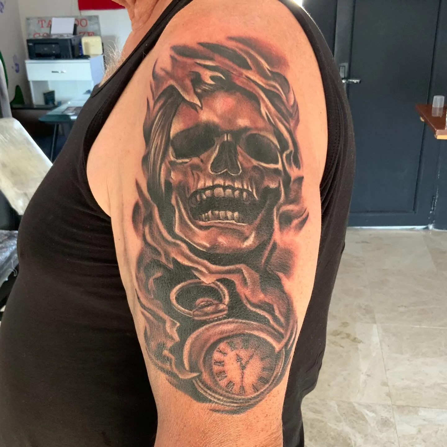 Black and grey skull, clock and roses sleeve tattoo