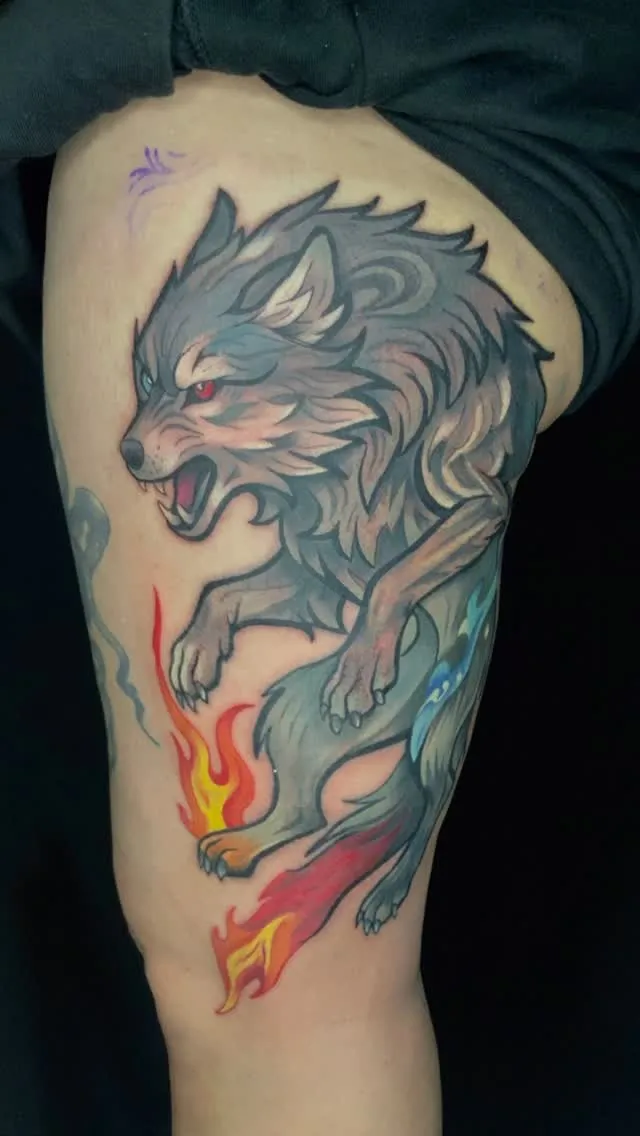 Colour wolf tattoo with flames on the leg